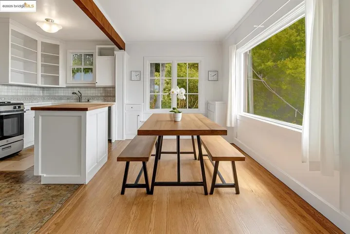 Kitchen featuring wooden counters, white cabinets, backsplash, a center island, and stainless steel range with gas stovetop