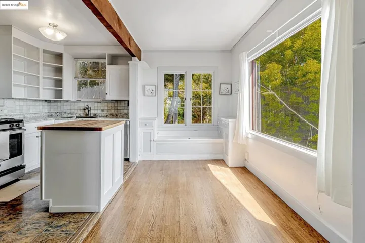 Kitchen featuring white cabinetry, butcher block counters, tasteful backsplash, open shelves, and stainless steel gas range
