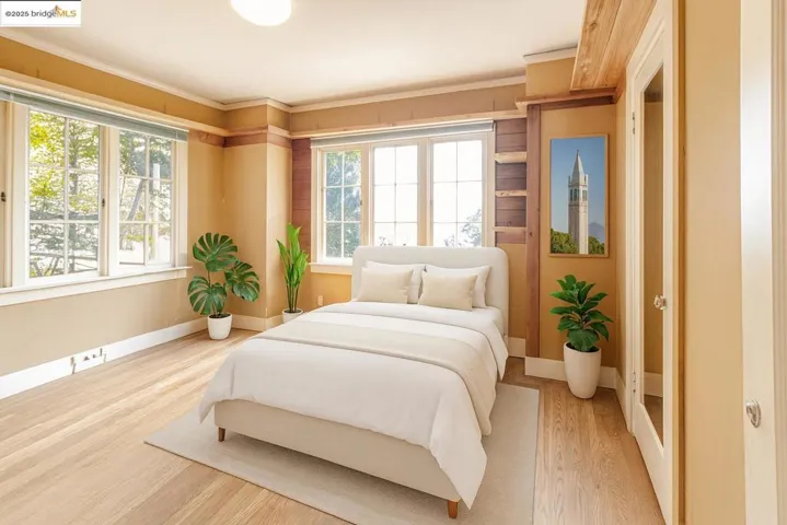 Bedroom with wood finished floors and ornamental molding