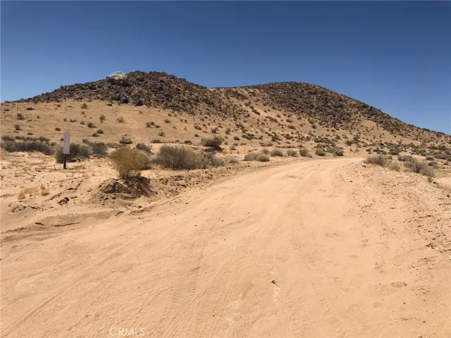 Your turn right here and go north to the lot. This is American Way. No Street sign. Look for the marker and the blue paint on the large rock on the hill.