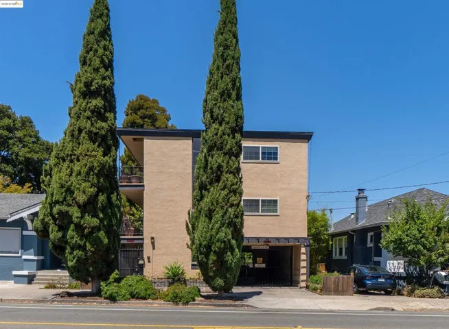 View of front of house featuring stucco siding, a balcony, and driveway