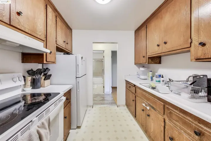 Kitchen with white range, light floors, light countertops, and brown cabinets