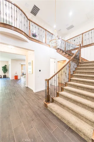 curved staircase with wrought-iron spindles and wood accents