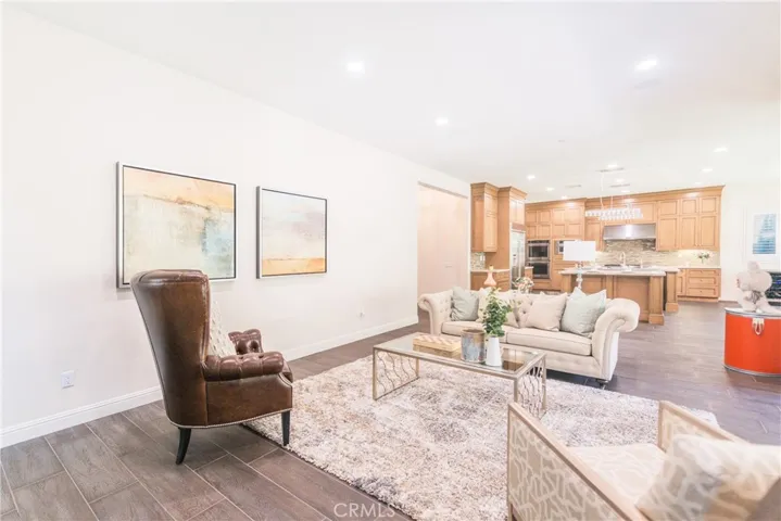 The spacious living room seamlessly opens to the kitchen area, creating an expansive, open-concept space perfect for entertaining and family gatherings.