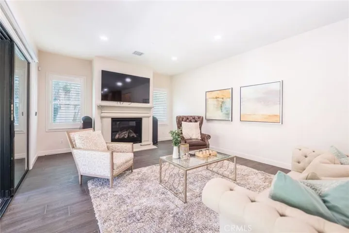 The living room centers around a cozy fireplace, creating a warm and inviting focal point perfect for relaxing or entertaining.