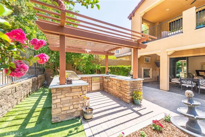 The backyard boasts a custom built-in BBQ with a granite countertop, creating a stylish and functional space perfect for outdoor cooking and entertaining.