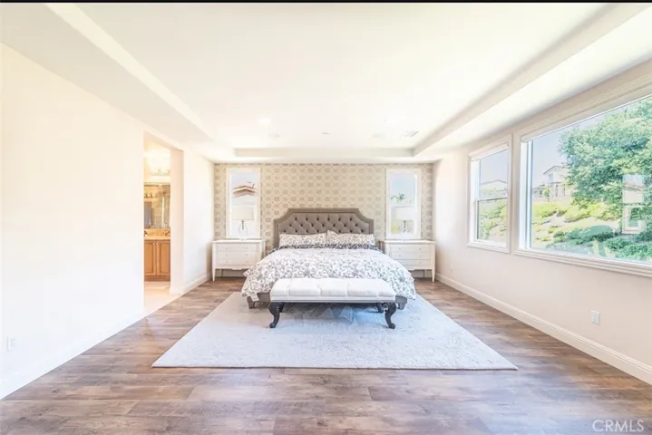 The oversized primary bedroom features large windows that overlook the backyard, filling the space with natural light and creating a serene, private retreat.