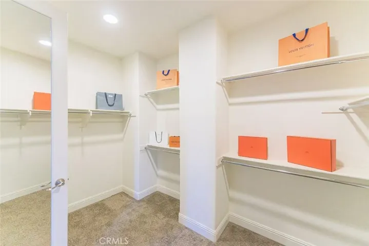 The primary bedroom features his-and-hers closets with plenty of storage, providing ample space and organization for a clutter-free retreat