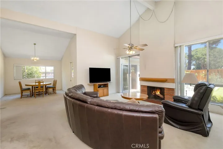 Living room and dining room have a grand feel with vaulted ceilings, fireplace, and tons of natural light.