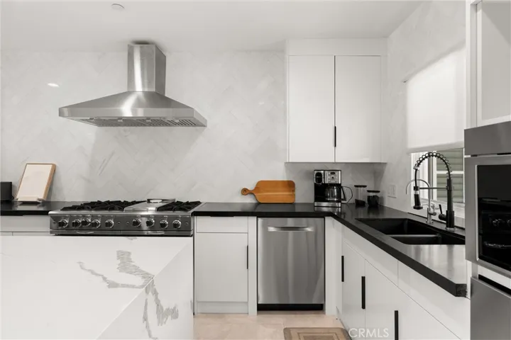 A functional U-shaped design offers ample counter space, a herringbone backsplash, and premium appliances for the home chef.