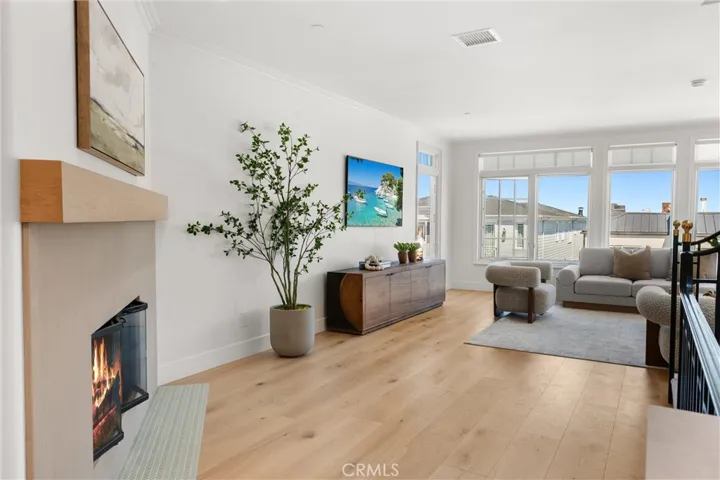 A new contemporary fireplace with a wood mantle creates a warm focal point in the spacious living room.