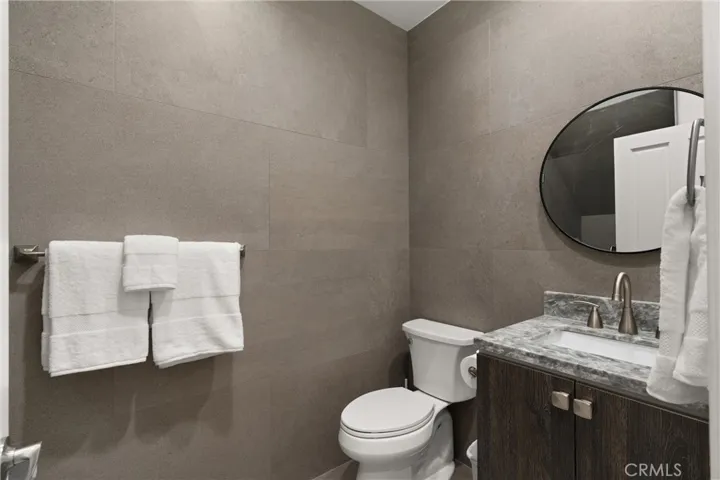 Designer guest bath with sleek stone counters, dark wood cabinetry, and top-tier fixtures.
