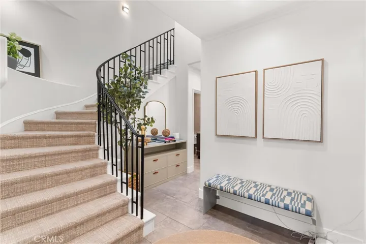 Stylish foyer with modern built-in cabinets for storage and grand staircase leading to the second floor.