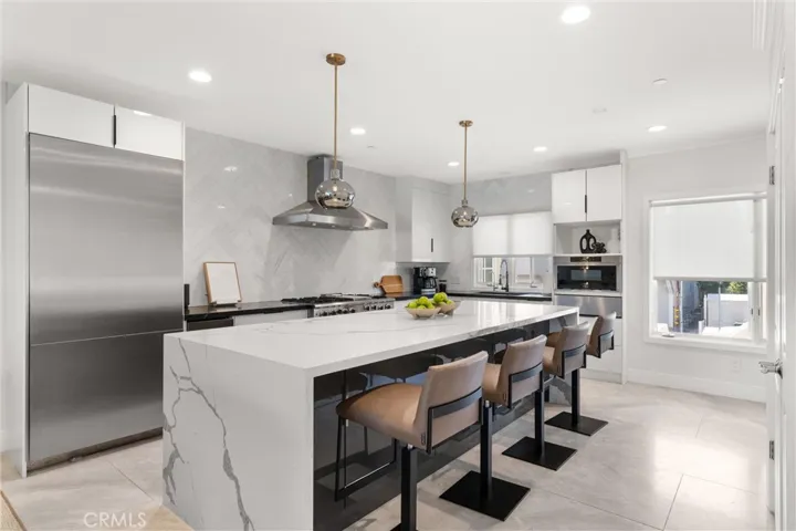 Entertain with ease at the expansive island, featuring stylish pendant lighting and seating for four.