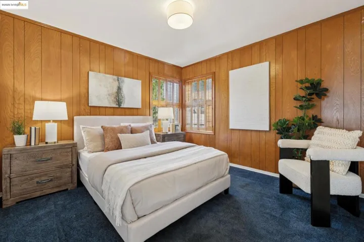 Carpeted bedroom with wooden walls and baseboards