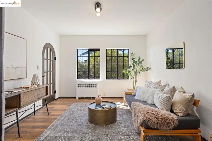 Living room featuring radiator heating unit, wood finished floors, and healthy amount of natural light