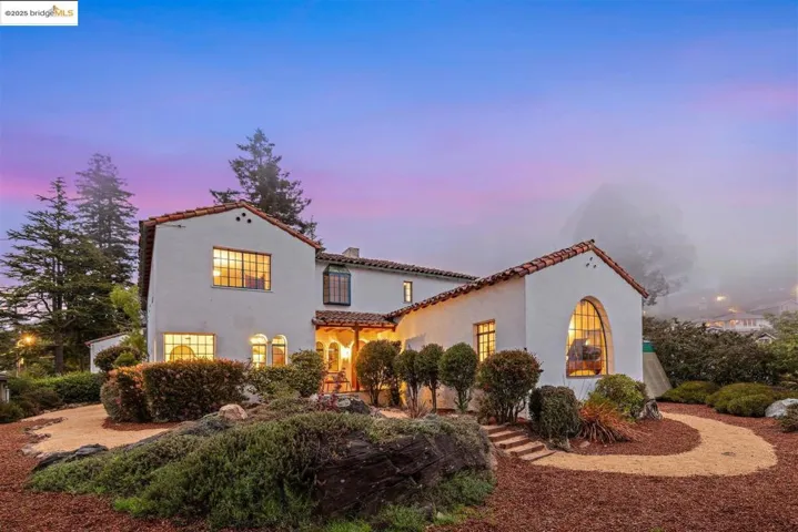 Mediterranean / spanish home featuring a tile roof, stucco siding, and a chimney
