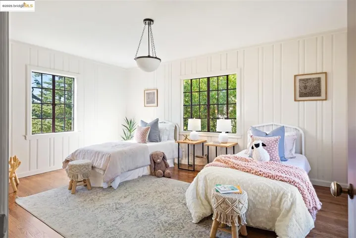 Bedroom with wood finished floors and multiple windows