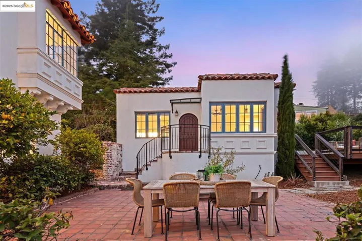 Patio terrace at dusk featuring a patio, outdoor dining space, and stairs