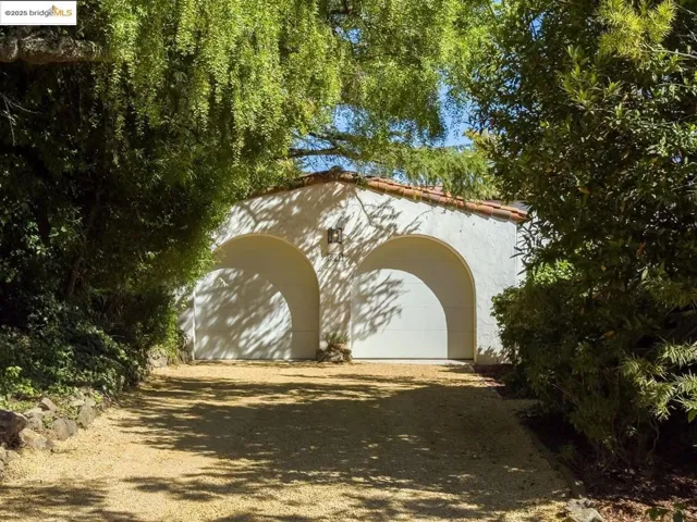 Exterior space with an outdoor structure, a tiled roof, and stucco siding