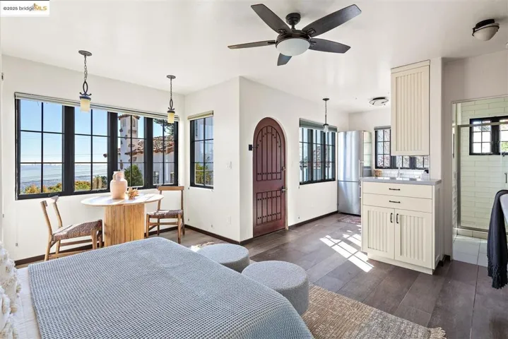 Bedroom with dark wood-style flooring, high quality fridge, and a ceiling fan