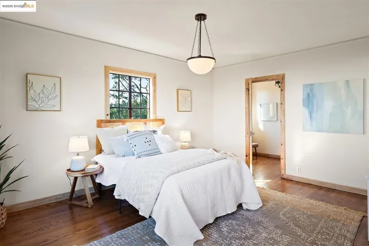 Bedroom featuring wood finished floors and ensuite bathroom