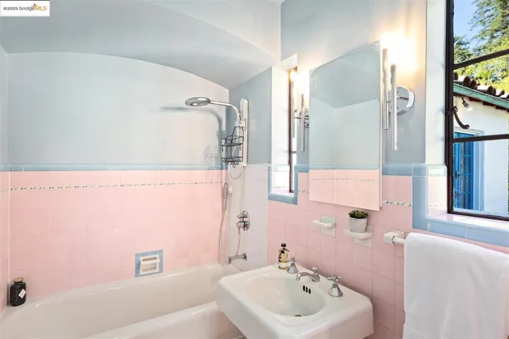 Bathroom with shower / washtub combination and tile walls