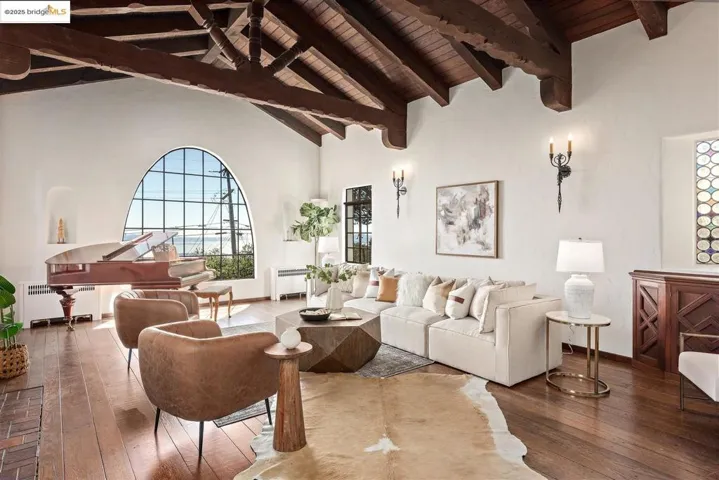 Living area with hardwood / wood-style flooring, high vaulted ceiling, radiator, and a wooden ceiling with exposed beams