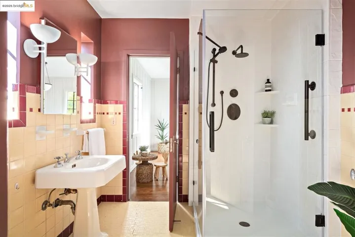 Full bath featuring a stall shower, tile walls, and tile patterned floors