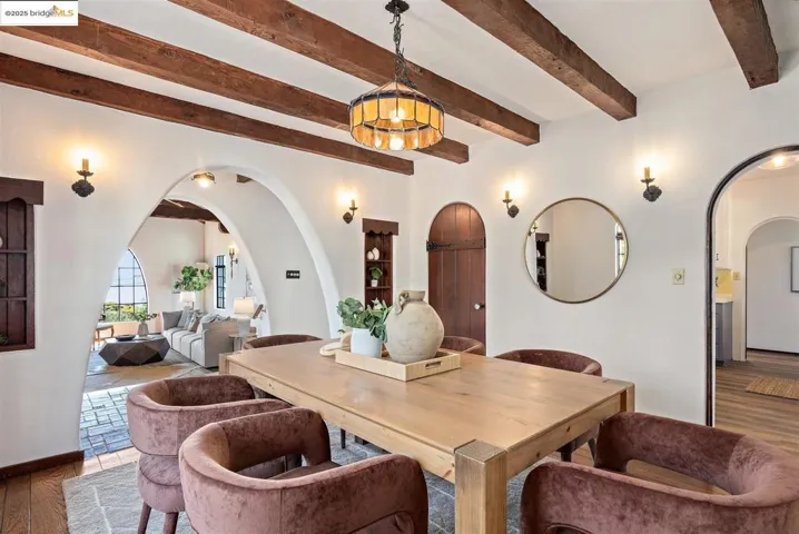 Dining room featuring arched walkways, wood finished floors, and beam ceiling