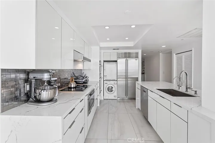 kitchen showing stackable laundry and sub zero refrigerator