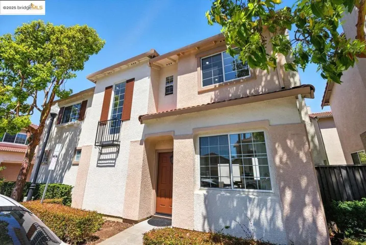 View of front facade with stucco siding and a balcony