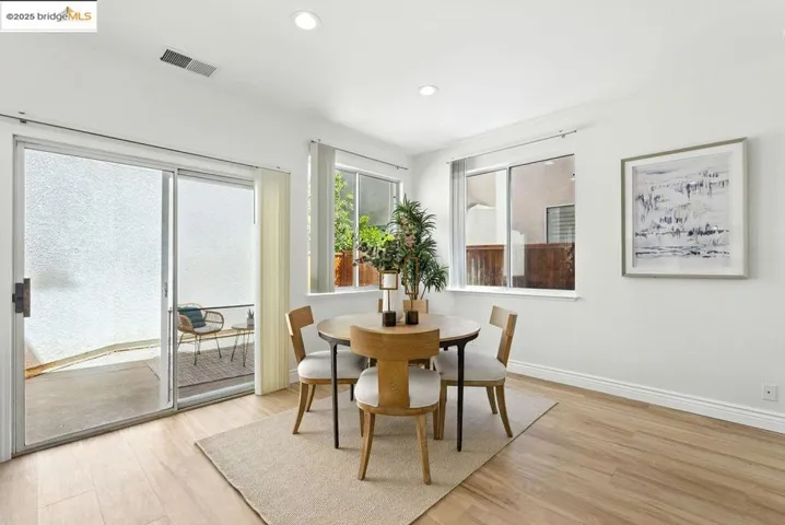 Dining area with light wood-style floors and recessed lighting