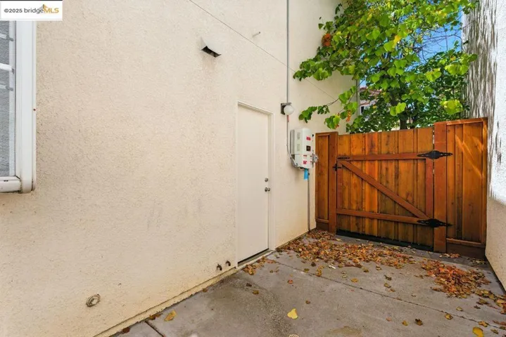 View of side of property with a gate and stucco siding