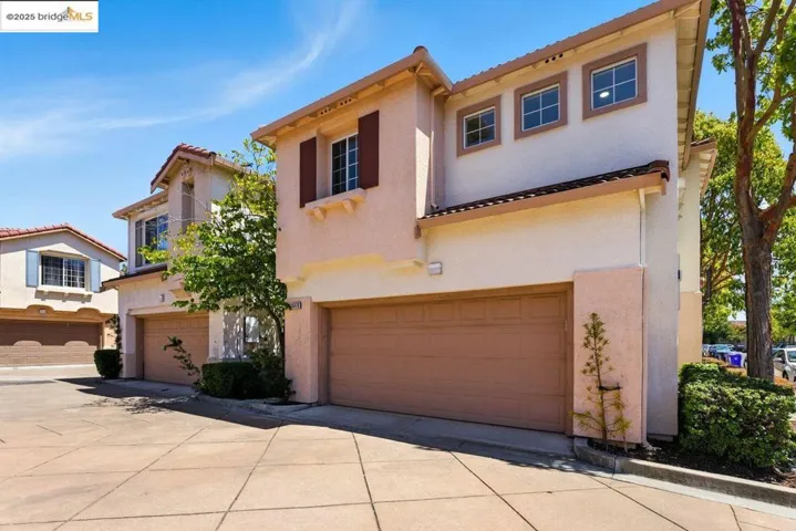 Mediterranean / spanish home featuring an attached garage, stucco siding, and driveway