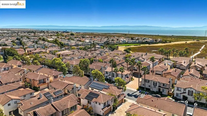 Aerial view of property's location featuring a water and mountain view and nearby suburban area