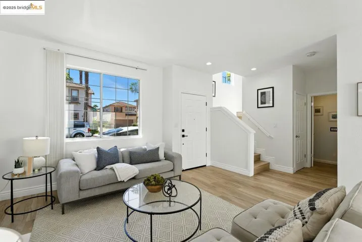 Living area with light wood-style flooring, stairs, and recessed lighting