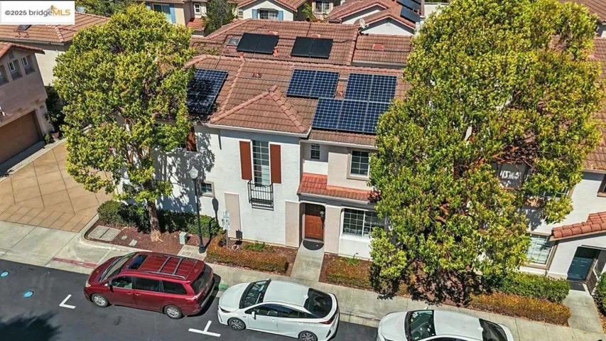 Traditional home featuring a tile roof, stucco siding, and solar panels
