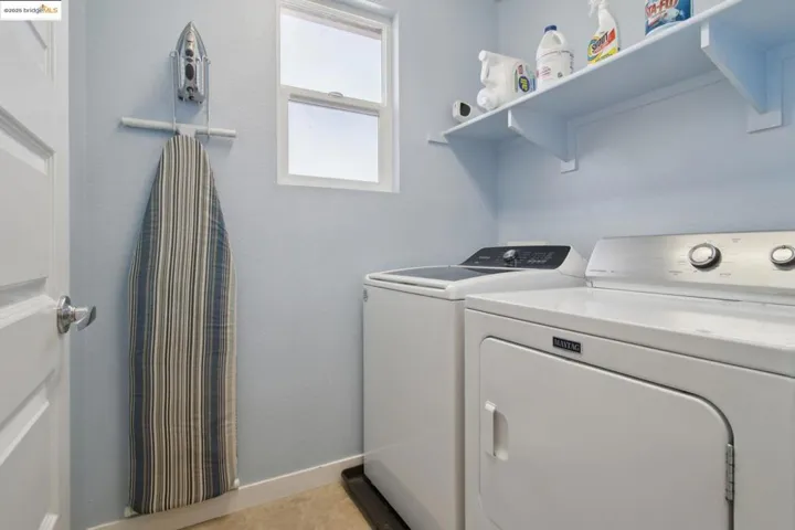Washroom with separate washer and dryer and baseboards