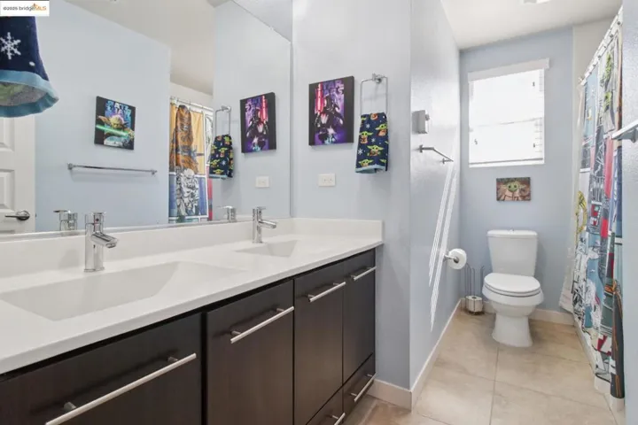 Bathroom with double vanity and light tile patterned floors