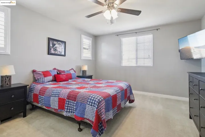 Bedroom with light carpet and a ceiling fan