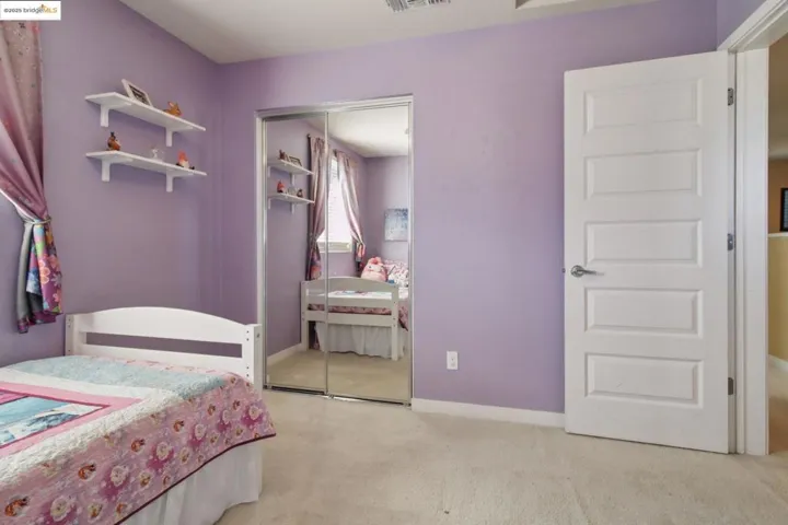 Bedroom featuring light carpet and a closet