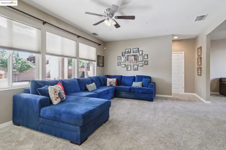 Carpeted living room featuring recessed lighting and a ceiling fan