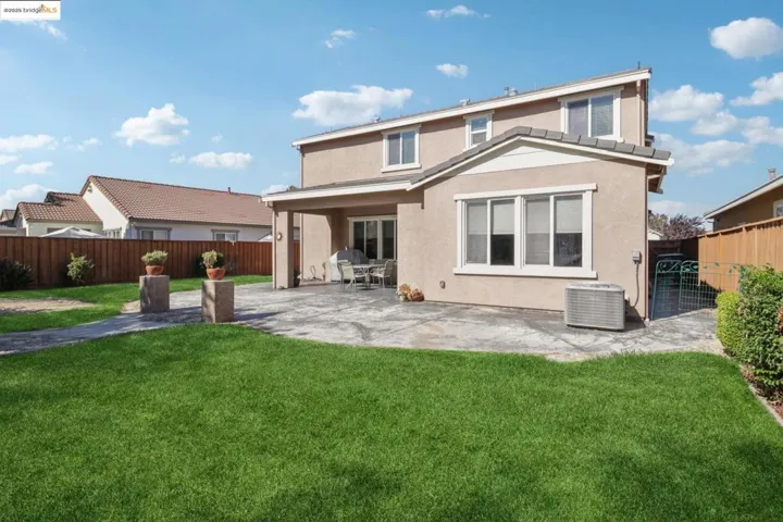 Rear view of house with a patio, stucco siding, and a fenced backyard