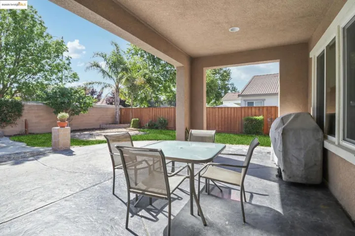 Fenced backyard with a patio, outdoor dining area, and area for grilling