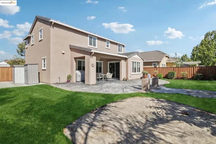 Rear view of property featuring a patio area, stucco siding, and a fenced backyard