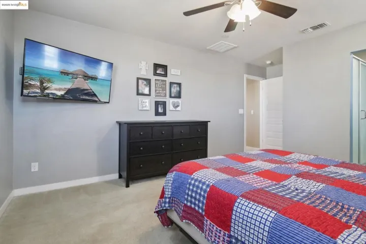 Carpeted bedroom featuring baseboards and a ceiling fan