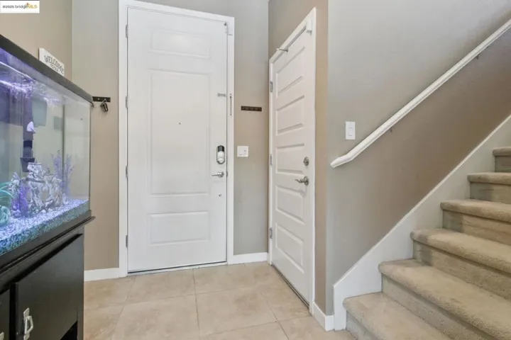 Foyer entrance with stairs and light tile patterned floors
