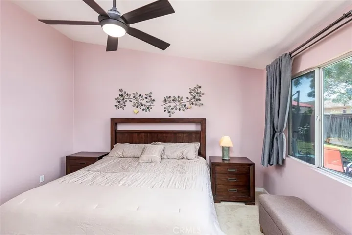 Primary bedroom with high ceilings and fan.