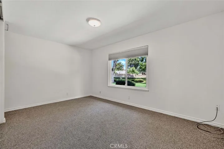 Primary bedroom looks out onto a large lawn.